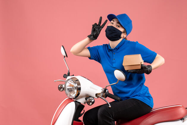 服务正面图：戴着面具的女快递员 带着粉红色的小食品包自行车送货食品