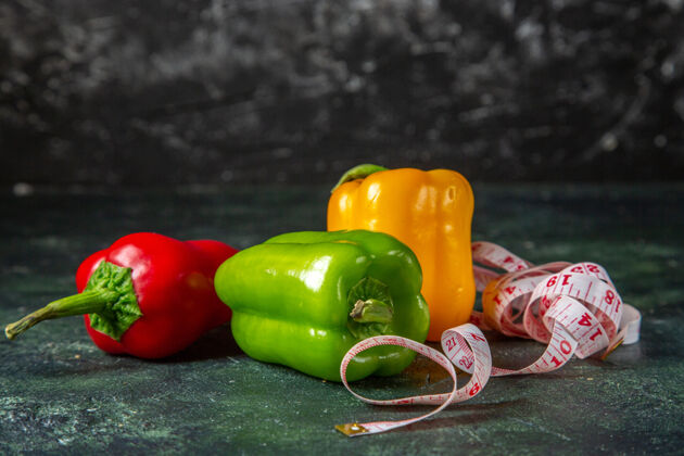 胡椒整个新鲜有机蔬菜的侧视图在混合颜色的背景下与自由空间甜椒辣椒蔬菜