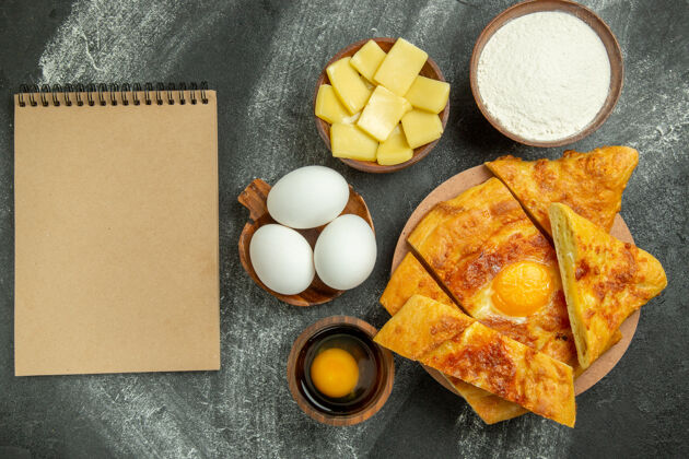 顶部顶视图烤鸡蛋面包与新鲜鸡蛋和切片奶酪灰色空间奶酪早餐餐
