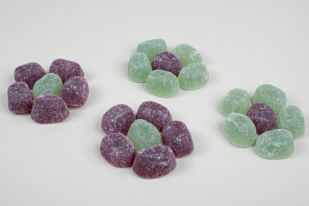 五颜六色绿色和紫色果冻糖果米色表面切片糖果果冻