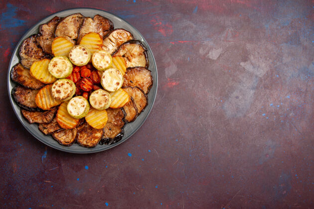 晚餐顶视图烤蔬菜土豆和茄子在黑暗的桌子盘子里烤箱午餐里面