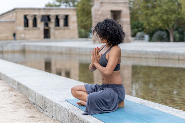 活跃一个西班牙女人在户外练习瑜伽的特写镜头运动员冥想练习