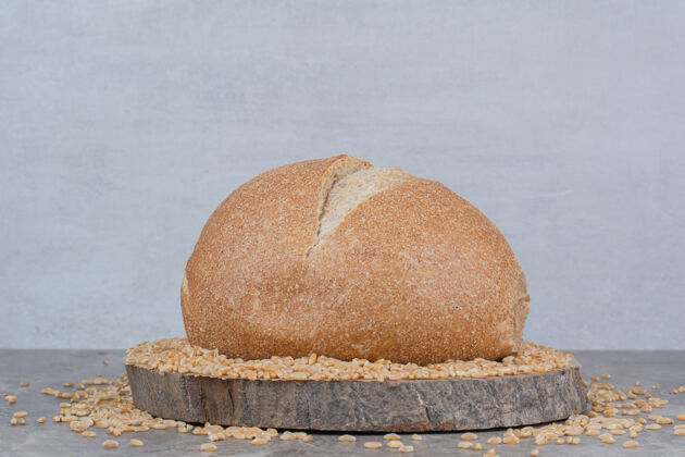 整个未煮的燕麦和面包放在大理石表面美味有机面包