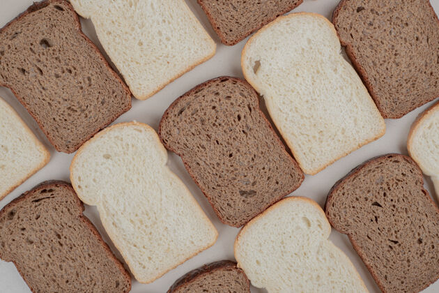 糕点把新鲜的白面包和棕色面包切片放在白色的表面上面包美味皮