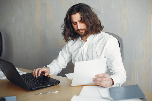 男穿着白衬衫的帅哥在办公室工作的商人拿着笔记本电脑的家伙西装行政自信