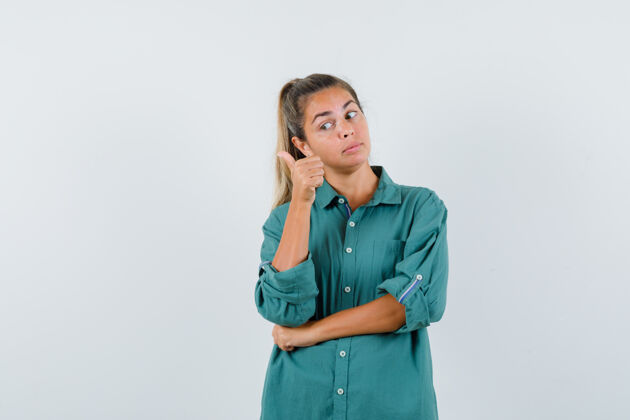 手指年轻女子站在思考的姿势 指着食指左在绿色衬衫 看起来沉思干净前面人