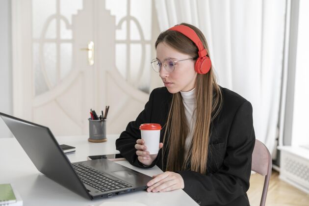 设备戴着耳机的中枪女人在工作耳机笔记本电脑