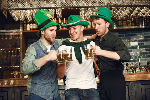 聚会戴绿帽子的男人朋友们庆祝圣帕特里克节在酒吧庆祝白天干杯圣帕特里克