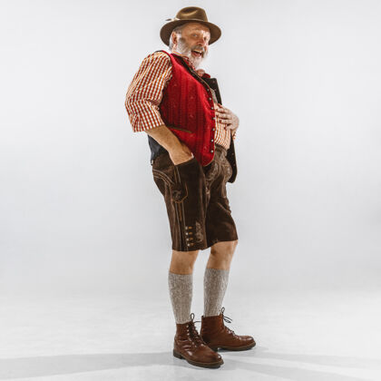 欧洲啤酒节老人的画像戴着帽子 穿着传统的巴伐利亚服装男人活动衣服