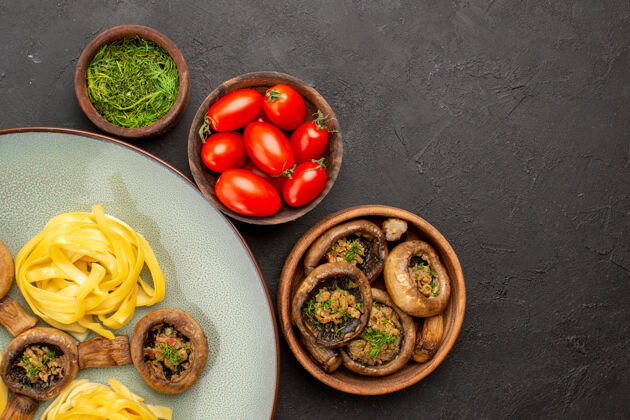 面食顶视图熟蘑菇面团面食上深色餐桌食物晚餐颜色番茄晚餐减肥食品