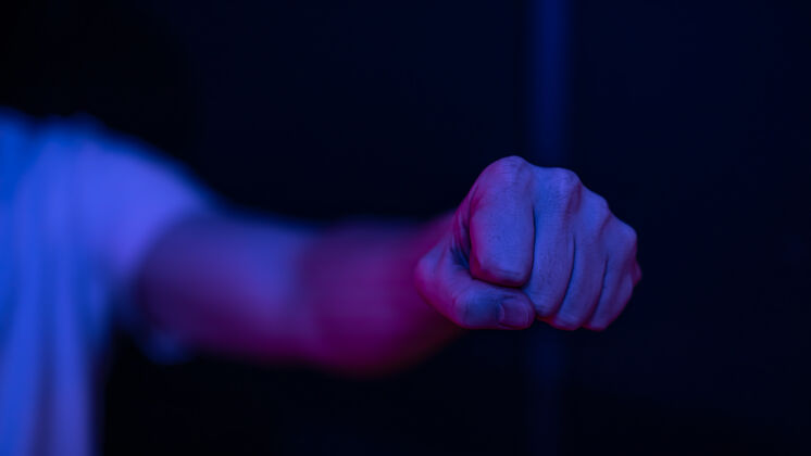 侵略性男性紧握拳头在模糊的墙上锻炼出冲击力和力量力量拳打手势