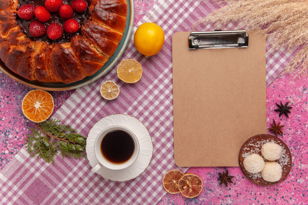 蛋糕顶视图美味的草莓馅饼与茶上的粉红色糖果椰子咖啡