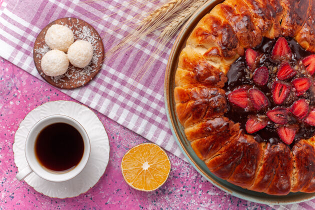 饼干俯瞰美味的草莓馅饼圆形水果蛋糕上的粉红色干的椰子茶