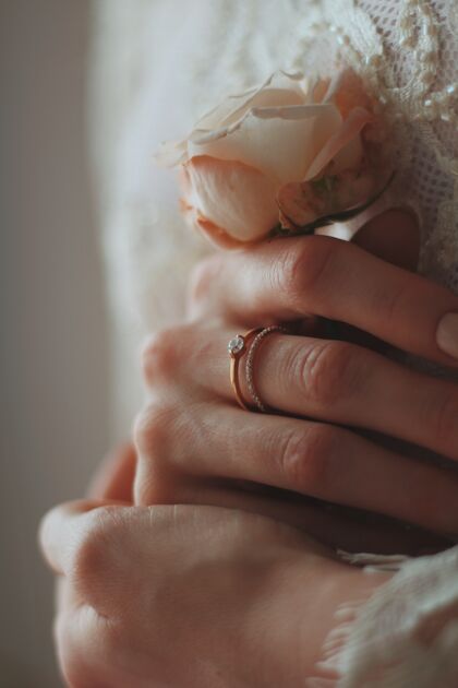 浪漫特写镜头中的新娘戴着一枚漂亮的钻戒 手里拿着一朵玫瑰玫瑰新娘珠宝