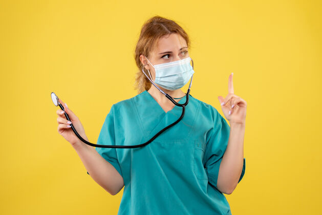 女医生黄墙上穿着医疗服 戴着听诊器面罩的女医生的正面图正面成人人