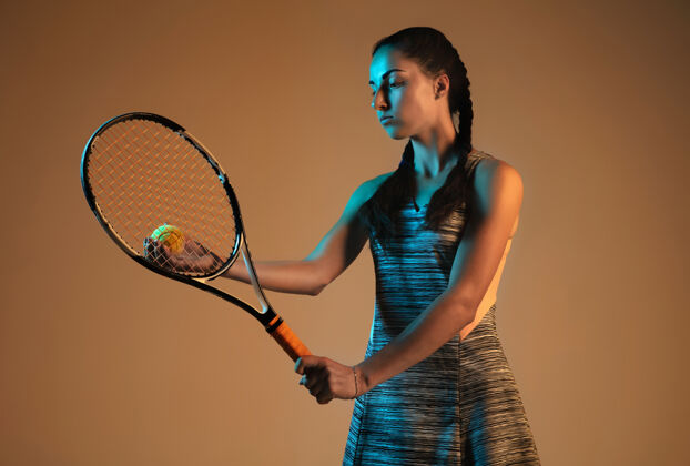阴影在棕色墙上打网球的女人混合光跑步