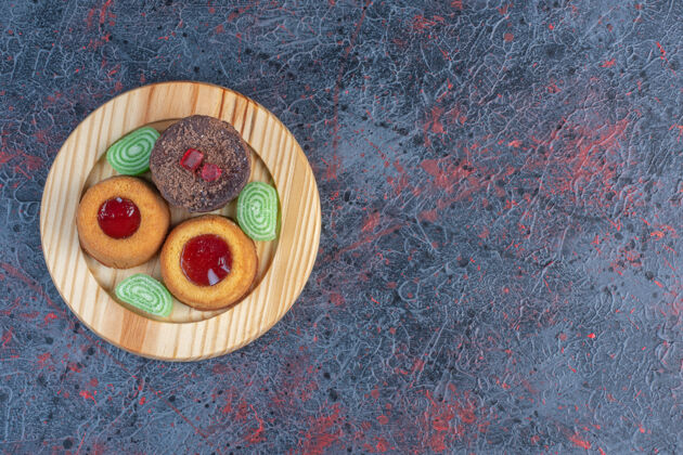 糕点抽象桌上的木盘上放着各种各样的蛋糕和果酱可口美味甜点