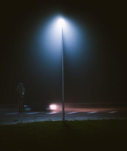 道路晚上拍摄的街边灯柱的垂直镜头旧欧洲汽车
