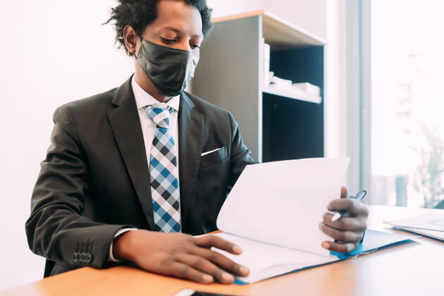 高管职业商人戴着口罩在办公室处理一些文件和文件纸张文件男性