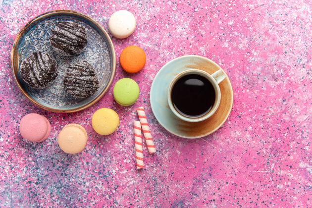 糖果顶视巧克力蛋糕与法国马卡龙粉红水果咖啡饼干