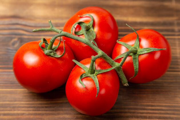 蔬菜正面近景红色西红柿棕色桌子上的成熟蔬菜红色成熟新鲜饮食沙拉李子西红柿健康食品