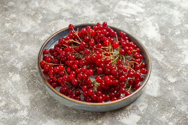 水果前视图新鲜的红色小红莓在托盘里放在白色的桌上 浆果的颜色是野红色灌木新鲜食用水果