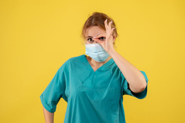人黄墙上年轻女医生穿着医疗服 戴着口罩的正面图肖像成人正面