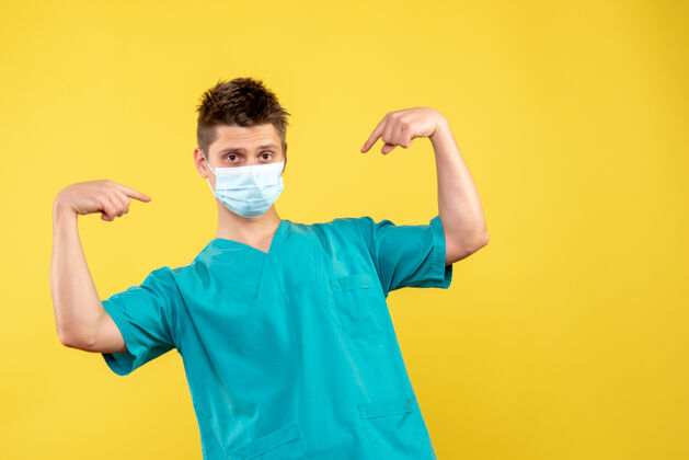 男医生黄墙上的男医生穿着医疗服 戴着无菌口罩面具人医学