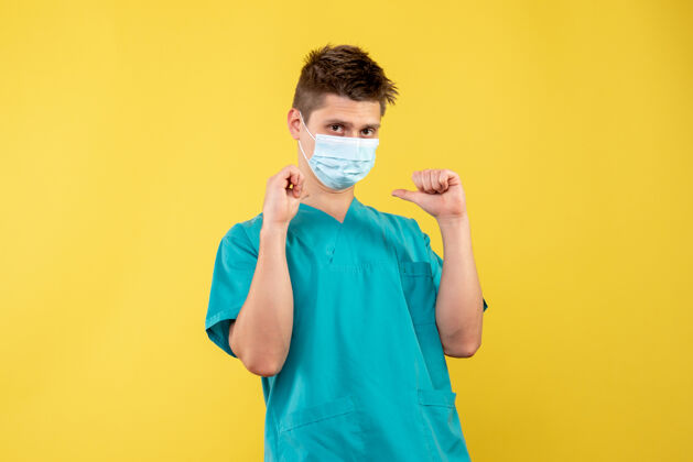 脸黄墙上的男医生穿着医疗服 戴着无菌口罩正面人面具