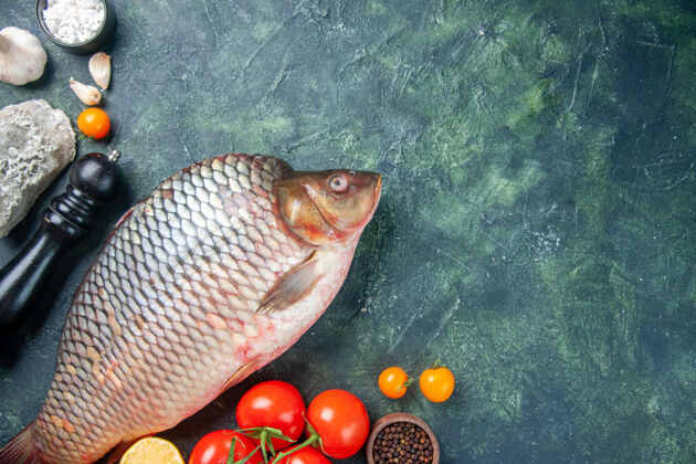 鱼顶视图新鲜的生鱼肉与西红柿和蘑菇在深蓝色的背景顶部水平蘑菇