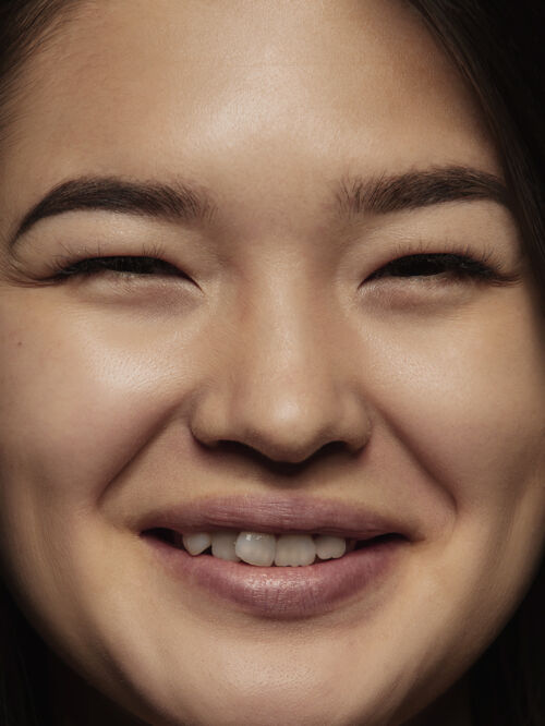 年轻年轻而富有感情的中国女性的特写肖像女性模特的高细节照片 保持良好的皮肤和明亮的面部表情人类情感的概念对着镜头微笑表情女性肖像