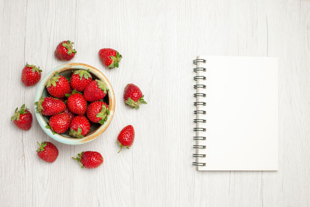 甜点顶视图新鲜的红色草莓在一个白色的桌子盘子里草莓浆果桌子