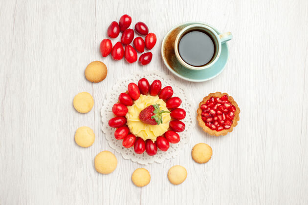 茶杯在白色的桌子上可以俯瞰一杯带有奶油蛋糕和水果的茶奶油零食食品
