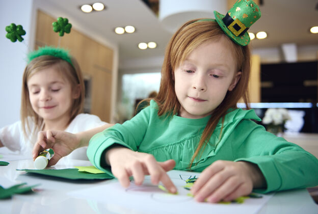 童年兄弟姐妹在爱尔兰聚会上做装饰品的画像享受爱尔兰准备