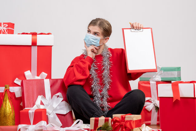 礼物正面图年轻女性围坐在圣诞礼物旁 带着纸条病毒礼物人