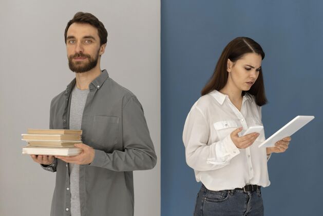 平板电脑背靠背的男人拿着书 女人拿着平板电脑设备放松科技