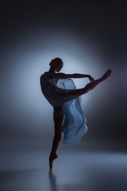 风美丽的芭蕾舞女演员在深蓝色背景下与面纱共舞的剪影舞蹈女孩魅力