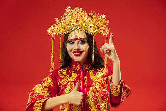 成人中国传统的优雅女子在红色背景的工作室里东方女演员新