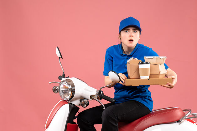 服务正面图：女快递员带着食品包和盒子上粉红色的工作人员送食品自行车制服服务工人男人自行车