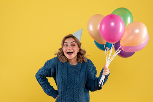 快乐正面图：带着彩色气球的年轻女性五颜六色欢乐飞机