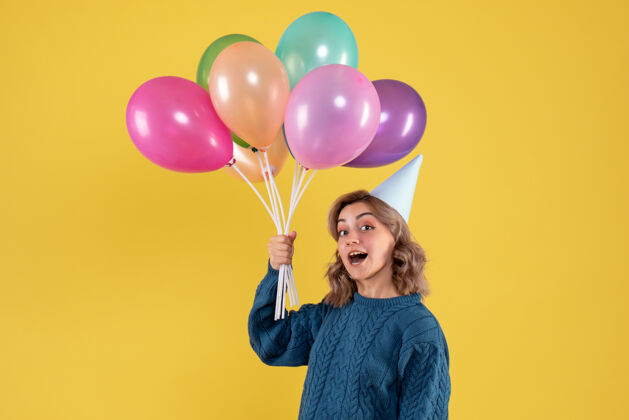 气球正面图：带着彩色气球的年轻女性一年圣诞节乐趣
