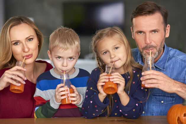 债券幸福家庭的画像喝冰沙玻璃杯万圣节健康的生活方式