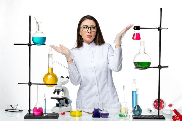 周围正面图：穿着无菌医疗服的女化学家站在桌子旁 拿着白色背景病毒疾病的解决方案-实验室流行病科学医学科学实验