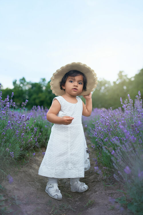 女孩可爱的女婴戴着草帽在薰衣草地里摆姿势时尚婴儿农场