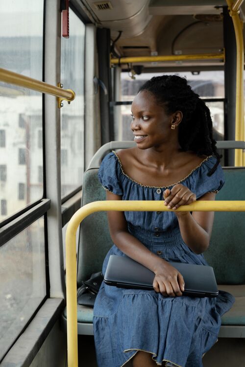 中镜头坐公共汽车旅行的笑脸女人女人旅行公共汽车