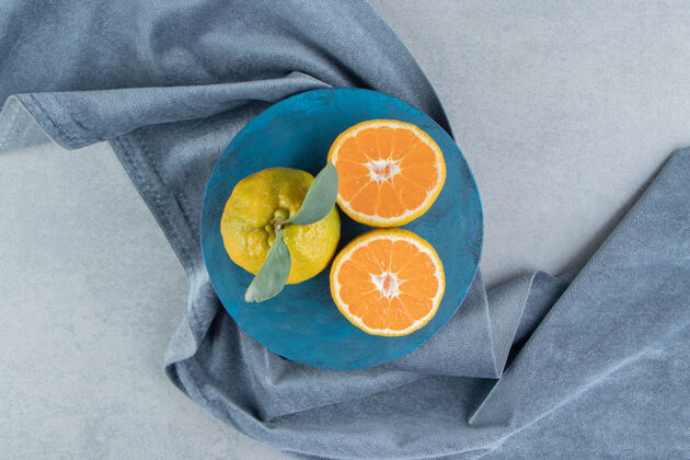 美味橘子在蓝色的木板上 在一块布上 在大理石上营养配料健康