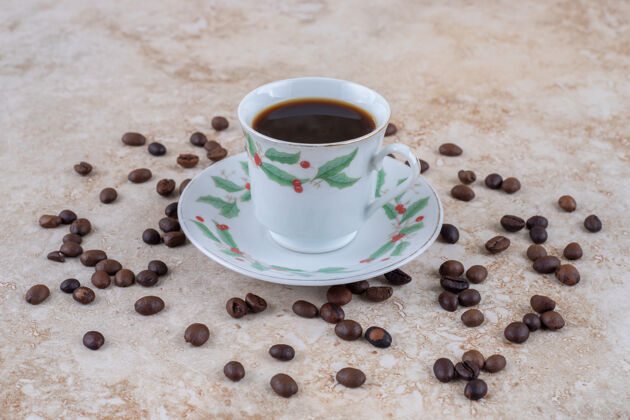 把咖啡豆撒在一杯咖啡周围茶碟美味咖啡豆
