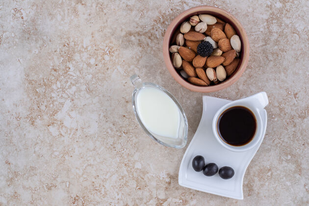 坚果一小碗牛奶 旁边是一碗什锦坚果和一杯咖啡美味各色咖啡