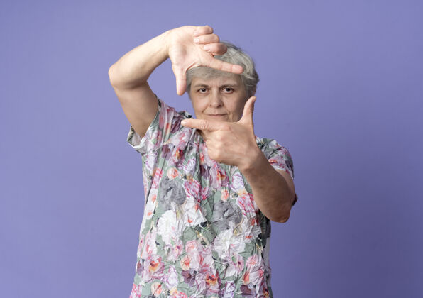 自信自信的老妇人手势框架手势孤立在紫色的墙上老人紫色手势