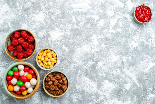 晚餐俯视不同的糖果与坚果和在白色空间的限制食品自封香料